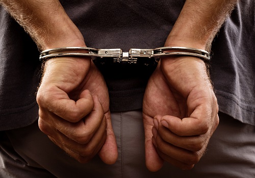 Handcuffed hands representing an arrest and criminal prosecution